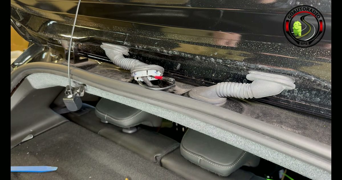 Caméra arrière de dashcam raccordée à son câble dans le hayon