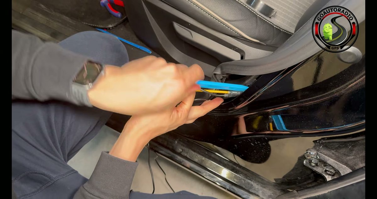 Outil plastique utilisé pour guider le câble de dashcam dans la garniture